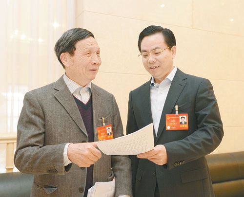 黃伯云代表（左）與劉國忠代表商討完善《關(guān)于建立戰(zhàn)略性新興產(chǎn)業(yè)國家創(chuàng)新平臺(tái)》的建議。 本報(bào)記者 張目 攝